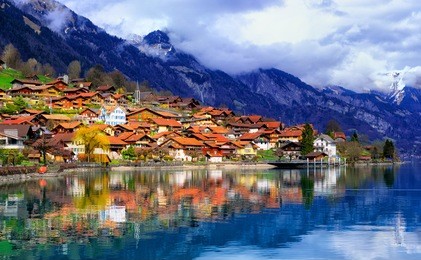 old town of oberried, brienz, interlaken and misty alps mountains reflecting in lake, switzerland