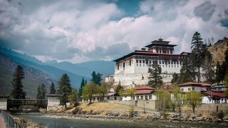 beautiful view of punakha dzong with blue sky, clouds, mountains, river, trees and sky. 
