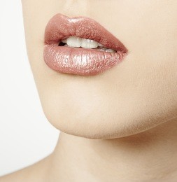 woman mouth close up with pink metallic lipstick