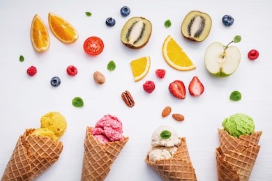 cones and colorful various fruits raspberry ,blueberry ,strawberry ,orange slice , half kiwi ,apple,tomato and peppermint leaves setup on white background . summer and sweet menu concept flat lay.