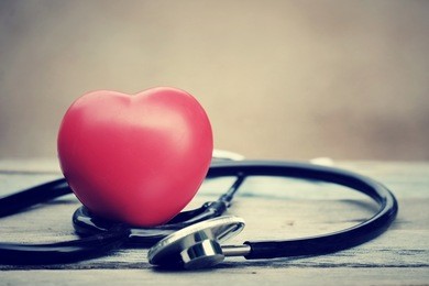 close up red heart and stethoscope on wood table, world health day concept, process vintage tone