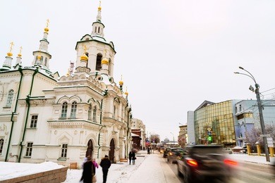 tyumen, russia. city center of siberian town tyumen, russia during the cold winter day, with church and car traffic on the road.