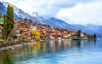 old town of oberried, brienz, interlaken and misty alps mountains reflecting in lake, switzerland