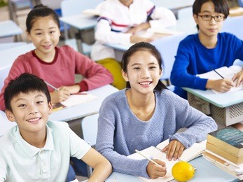 asian grade school students sitting in classroom, high angle view.