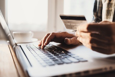 man holding credit card and using laptop. online shopping concept