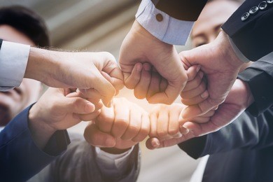 business people joining hands showing teamwork and support.