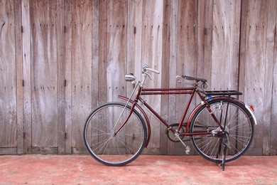 classic bicycle parked against wooden wall
