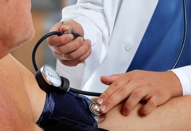 doctor measuring blood pressure with sphygmomanometer