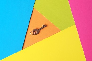 golden key on a multicolored background, top view. trendy colorful photo. minimal style with colorful paper backdrop. flat lay concept: golden key on pastel background. trendy minimal flat lay concept