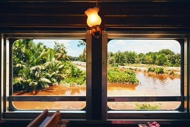 view from old steam train passing through countryside in malaysia - selective focus on the window