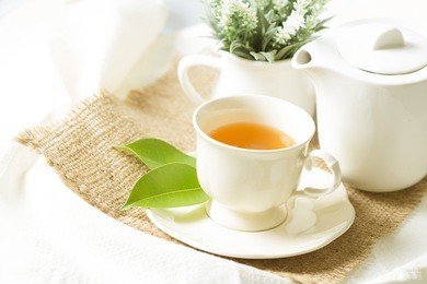 organic tea in white cup with green leaf , tea ceremony time concept 