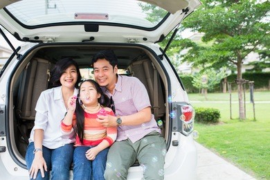 asian family summer activity. father ,mother and daughter sitting back of car for travel in the outdoor.