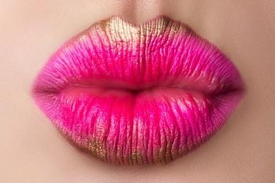 close up view of beautiful woman lips blowing a kiss. modern pink and gold makeup. studio shot. lips cosmetics, healthy skin and tooth, modern makeup or happy woman concept