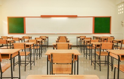 school classroom with desks chair wood, and greenboard in high school thailand, vintage tone education concept.