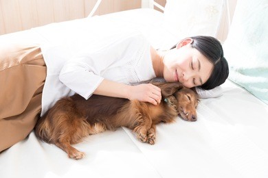 young asian woman sleeping with dog