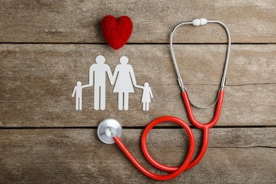 red heart, stethoscope and paper chain family on wooden table, health insurance concepts