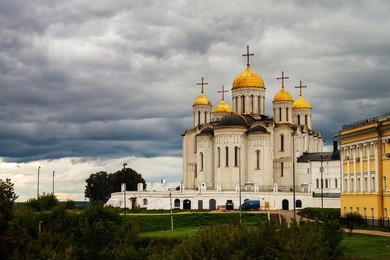 vladimir, russia. church the assumption cathedral of vladimir in summer, russia. one of the landmarks during the sightseeing golden ring tour. green grass and trees at the background. sky with clouds.