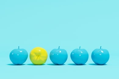 outstanding yellow apple contrast blue appples on blue pastel background. minimal concept.