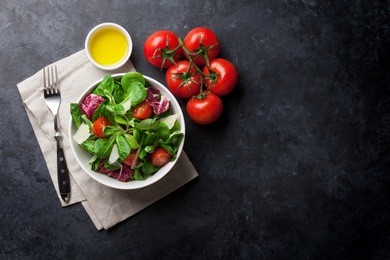 healthy salad bowl on stone table. top view with copy space