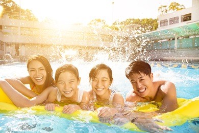 happy family playing in swimming pool