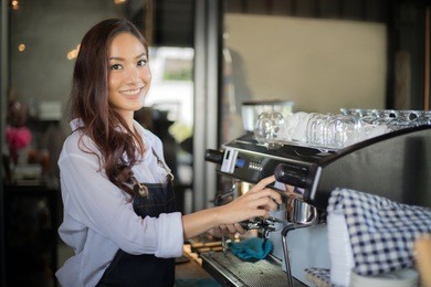 asian women barista smiling and using coffee machine in coffee shop counter - working woman small business owner food and drink cafe concept