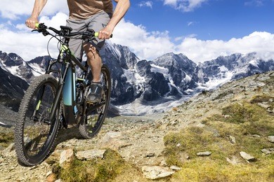 single mountain bike rider on ebike rides up a steep mountain trail.
