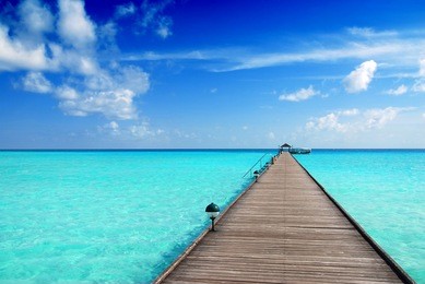 wooden jetty over the beautiful maldivian sea with blue sky