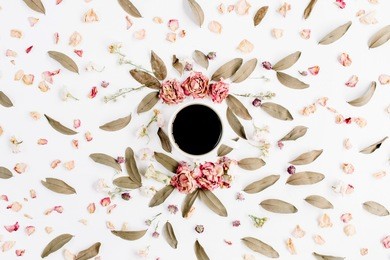 round frame wreath pattern with roses, coffee cup, pink flower buds, branches and dried leaves on white background. flat lay, top view. flower mockup background