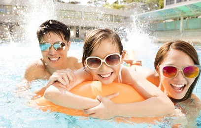happy family playing in swimming pool