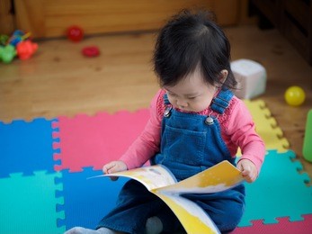 asian baby girl reading book 