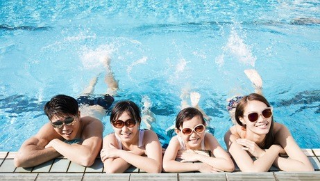 happy family playing in swimming pool