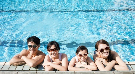 happy family playing in swimming pool