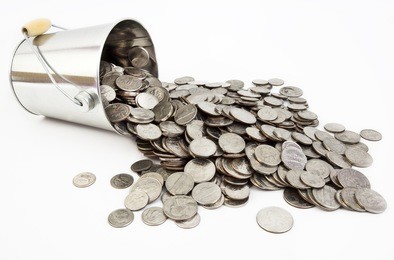 united states silver coins spilling from silver pail. isolated.