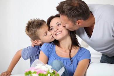 father and son kissing mother on her birthday