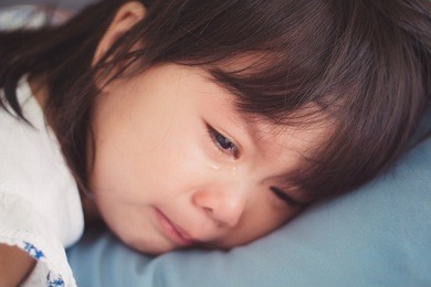 crying little asian girl on the bed.sad and depressed little girl in the bed.