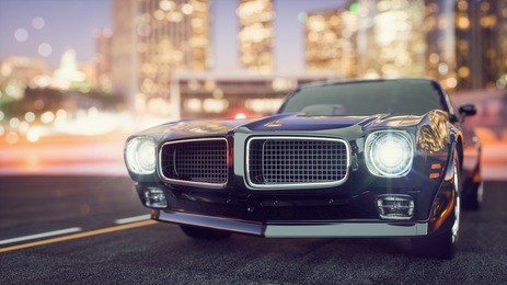 classic cars are in town at night.