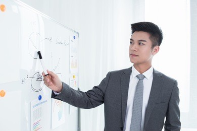 young business man or teacher showing on white board