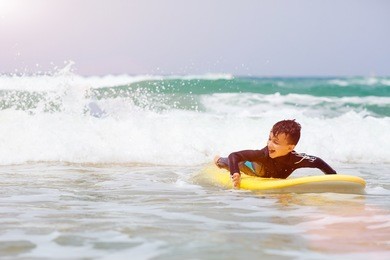a young surfer is looking at the ocean. portugal
