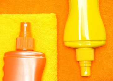 cosmetic sunscreen products on terry towels. selective focus on orange bottle