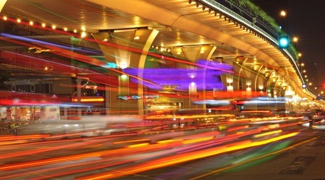 high speed traffic and blurred light trails under the overpass at night scene