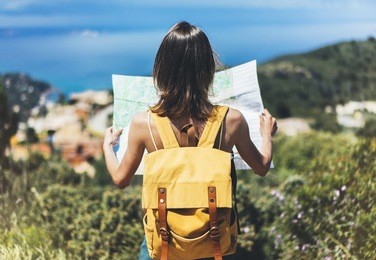 hipster tourist hold and look map on trip, lifestyle concept adventure, traveler with backpack on background mountain and blue sea landscape horizon, young girl hiker pointing hands on trekking plan