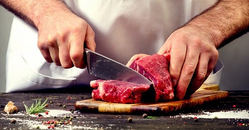 man cutting beef meat.