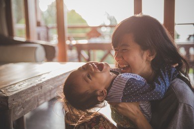 happy loving family. mother and child girl playing, kissing and hugging