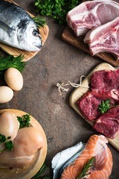 selection of protein sources at stone table. meat, chicken, fish, egg. top view copy space. animal protein food.