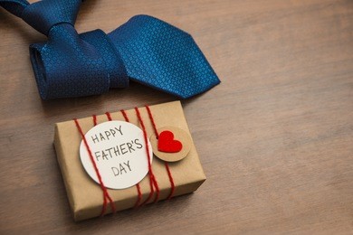 gift box with red heart and ribbon, blue tie and father's day card . striped tie near present box. best quality gifts for dads. happy father's day idea, sign, symbol. holiday background