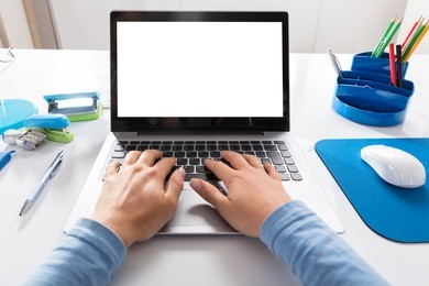 close-up of a woman working on laptop at workplace