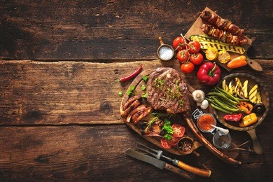 grilled meat and vegetables on rustic wooden table