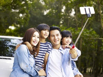 asian family with two children taking a selfie during a trip.