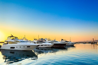 luxury yachts docked in sea port at sunset. marine parking of modern motor boats and blue water. tranquility, relaxation and fashionable vacation.