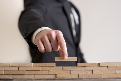 concept of business strategy-  businessman placing wooden blocks on table.